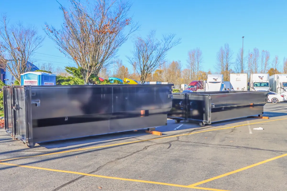 Professional dumpster rental service with roll-off container on residential driveway in West Livingston